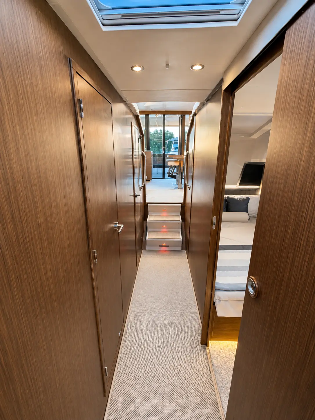 Below deck corridor with skylight and cabins either side