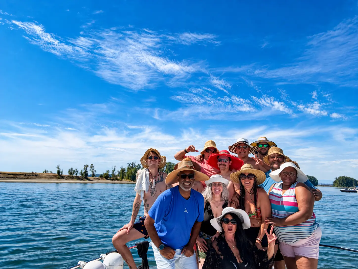 Guests on the bow near a sandbar under blue sky
